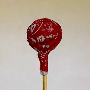 A red lollipop on a stick with white text and designs.