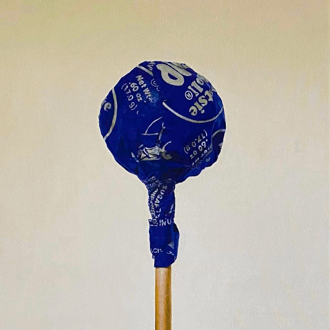 A blue lollipop with white text on a stick.