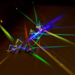 Prisms refracting colorful light beams in darkness.