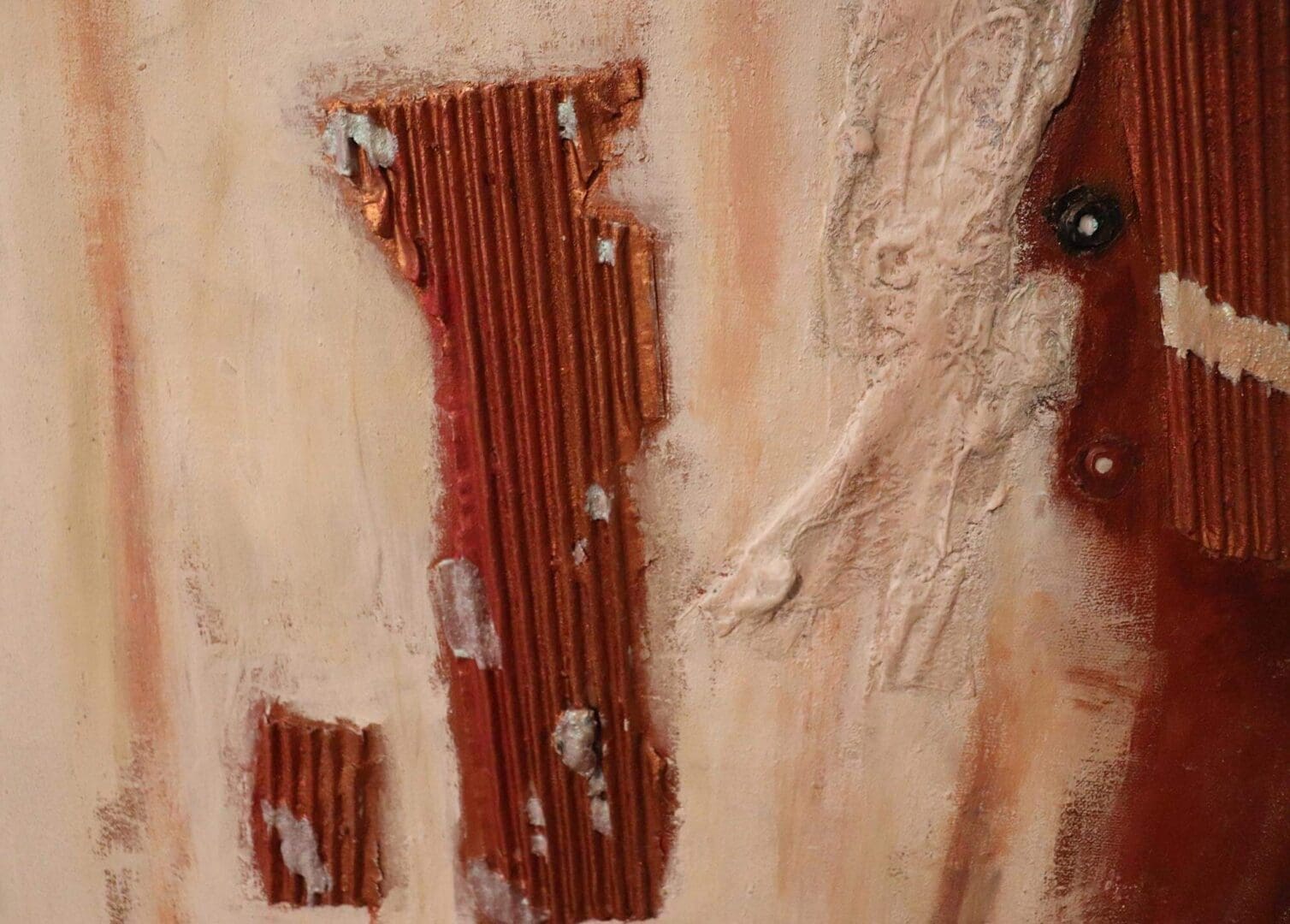 A close-up of a worn fabric with holes and rust-colored stripes.