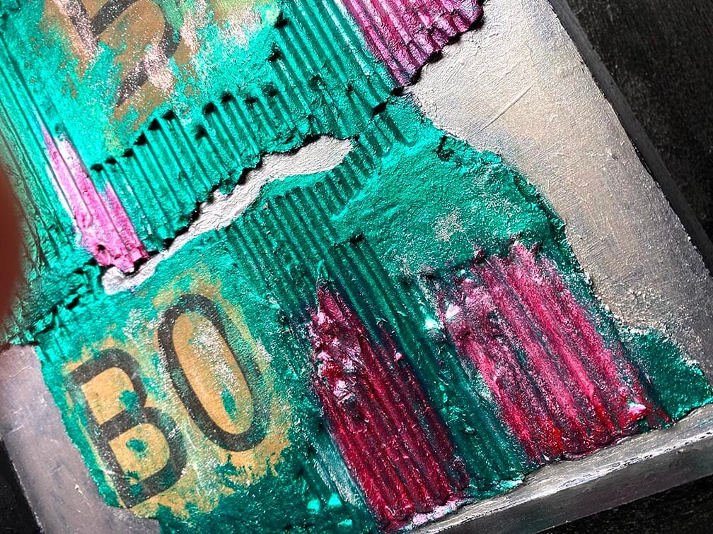 Close-up of colorful textured artwork with letters and shapes.
