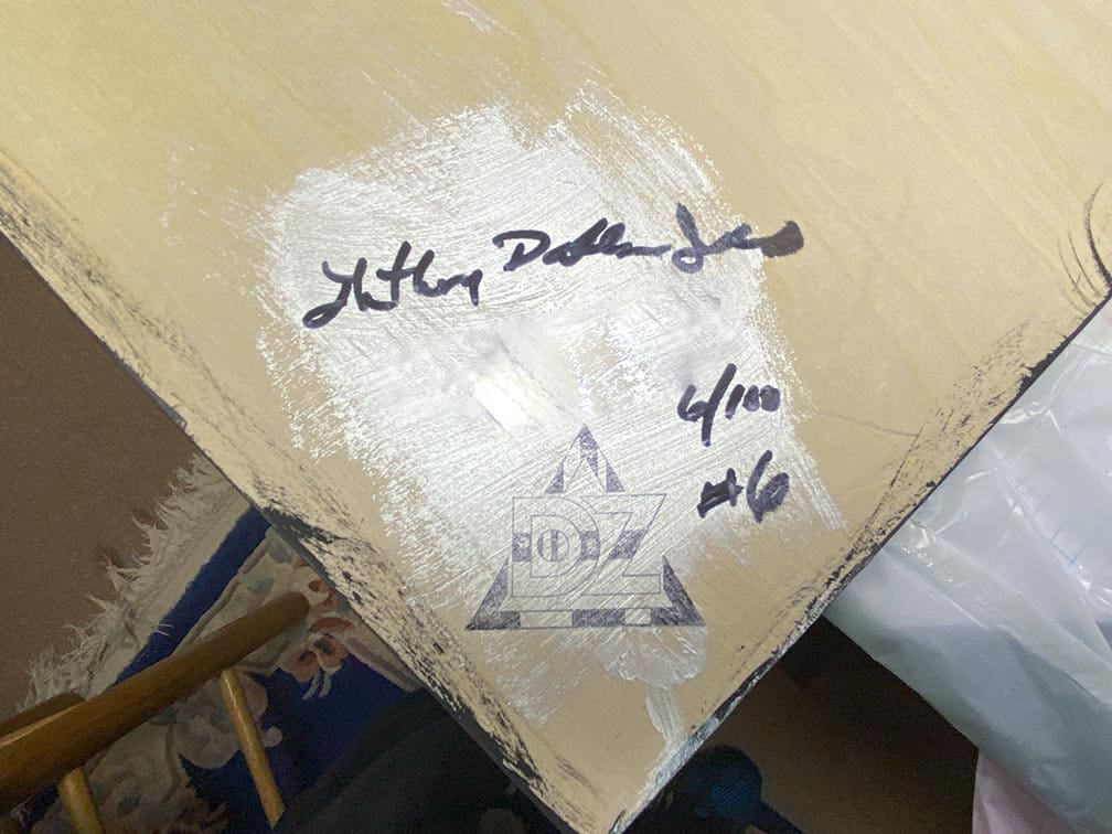A signed surfboard with inscriptions and markings.