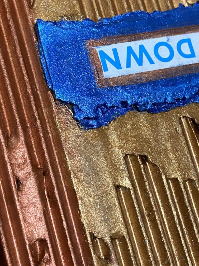 Close-up of textured surfaces with a blue label reading 'DOWN'.