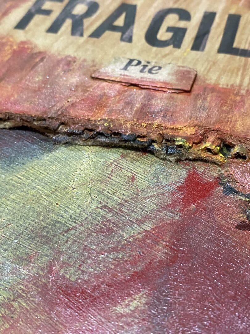 Close-up of a pie label on a textured, painted surface with earthy tones.