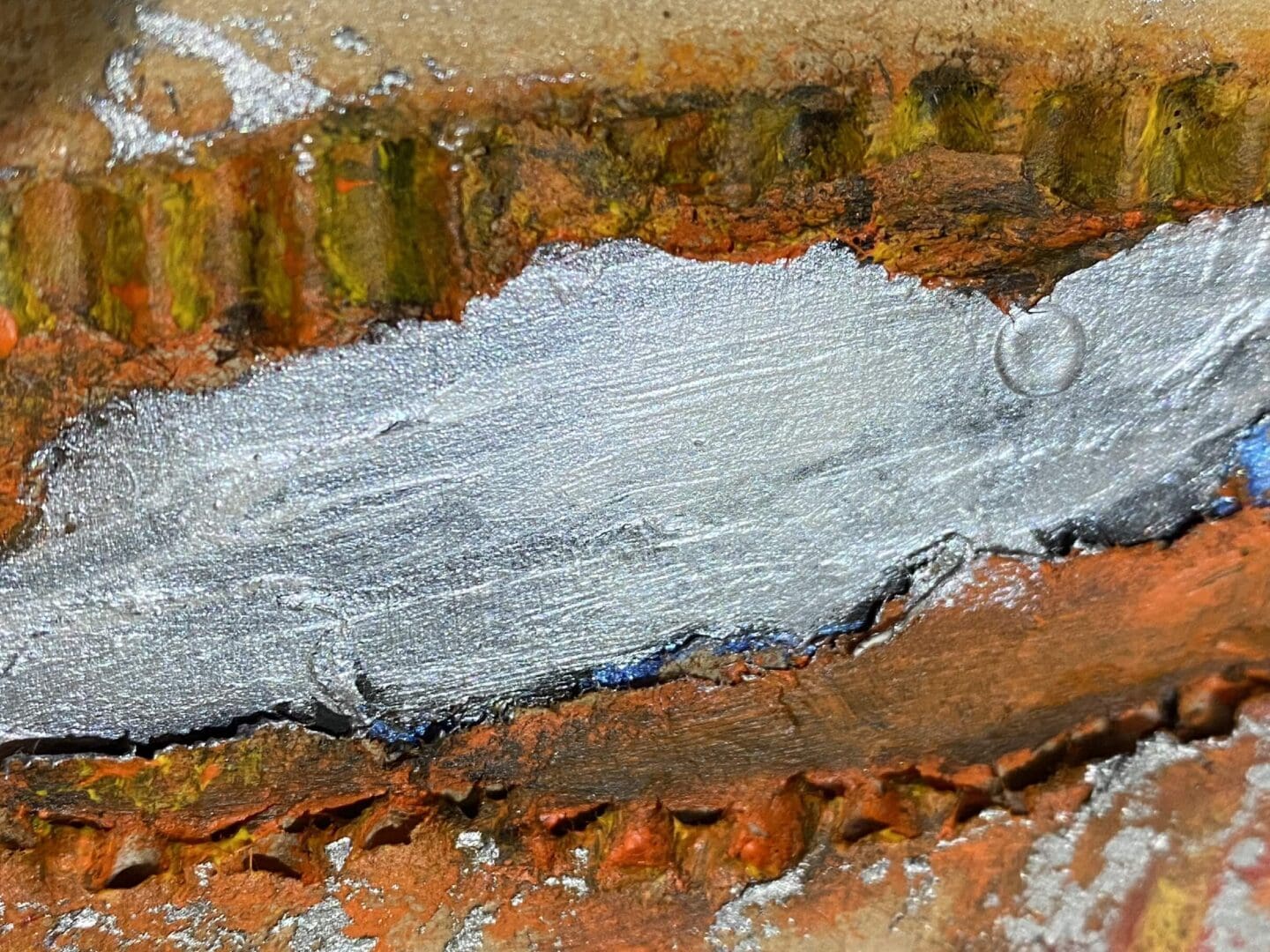 A close-up of rusty metal with peeling silver paint.
