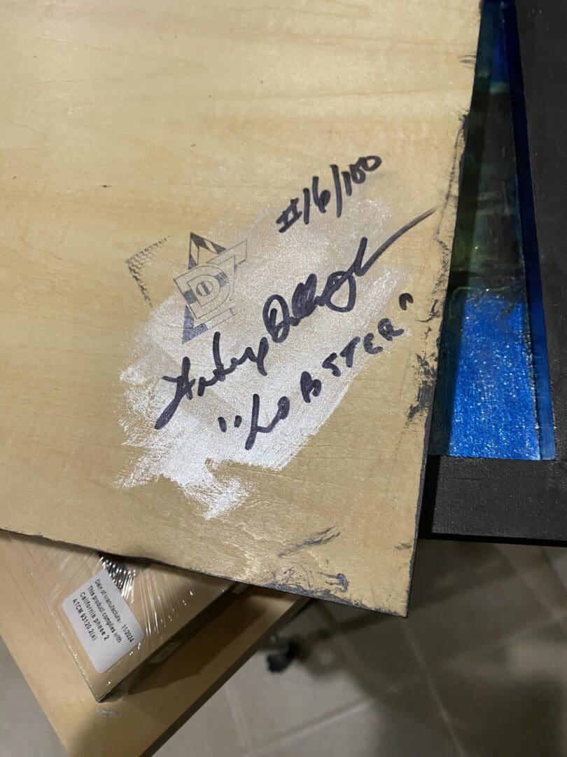 Close-up of a torn label on a cardboard box with handwritten text.