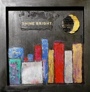 Colorful city skyline with a shining moon and 'Shine Bright' text.