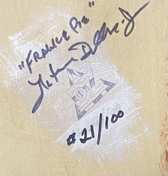 Close-up of an autograph with edition number on a textured surface.