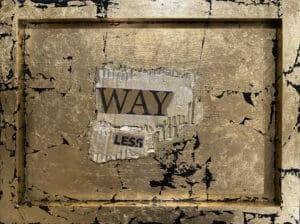 A weathered sign with the words 'WAY LESS' on a distressed wall.