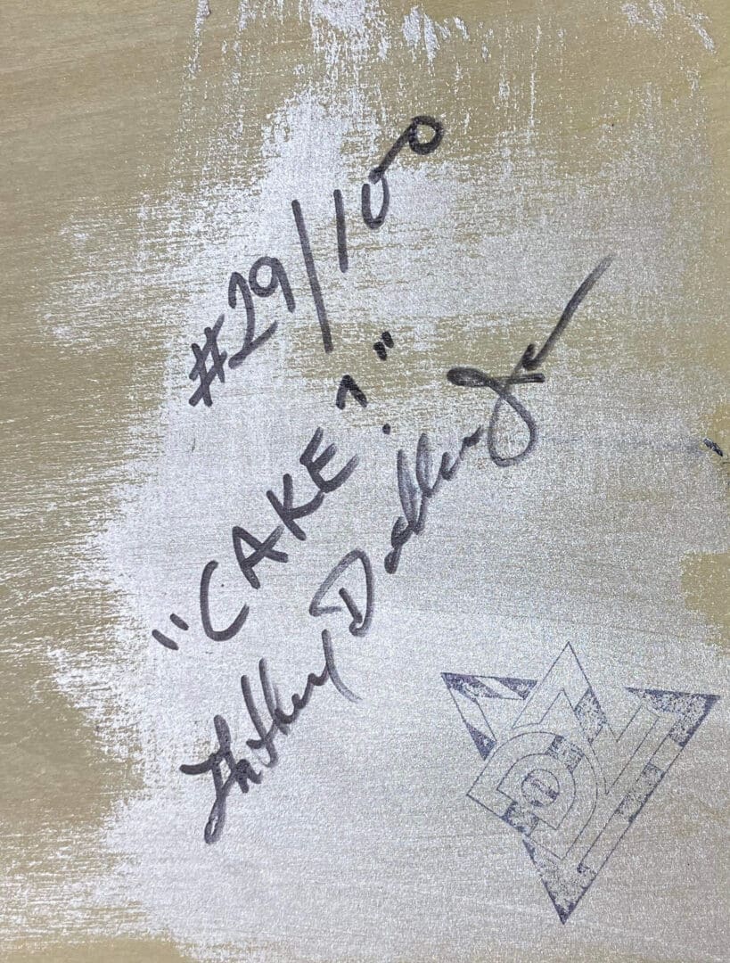 Close-up of a handwritten note with a signature and a cat doodle.