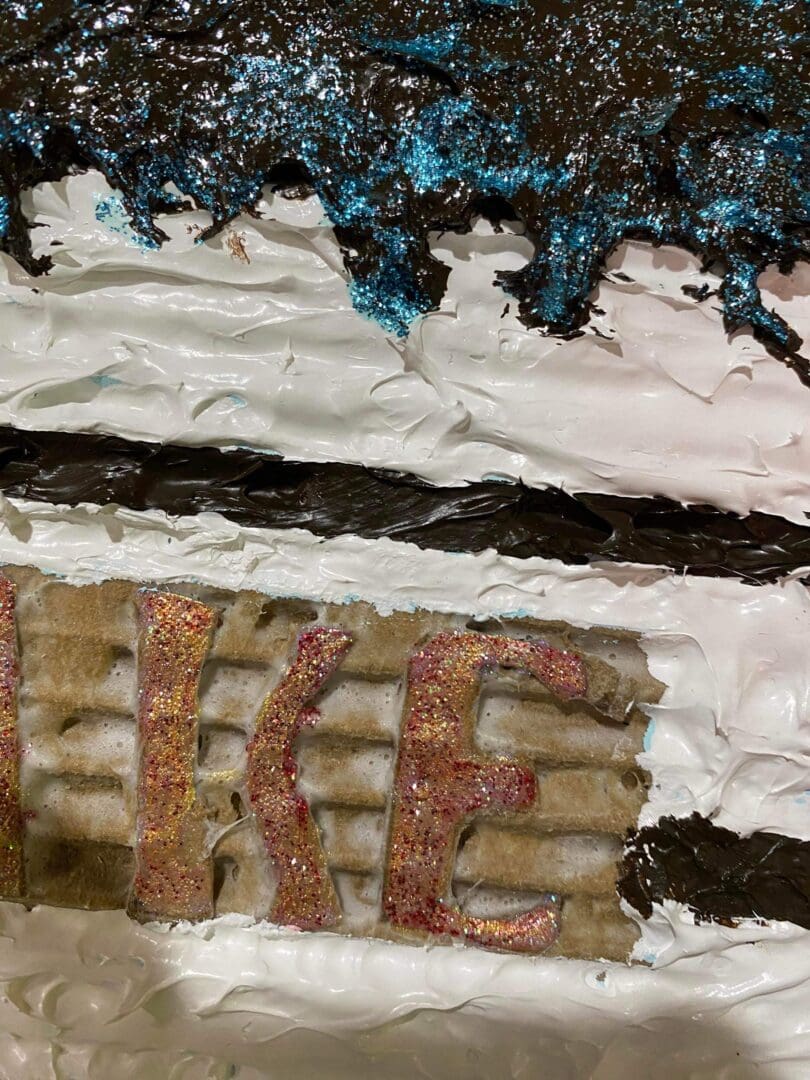 Close-up of a cake with the word 'LIKE' decorated on it.