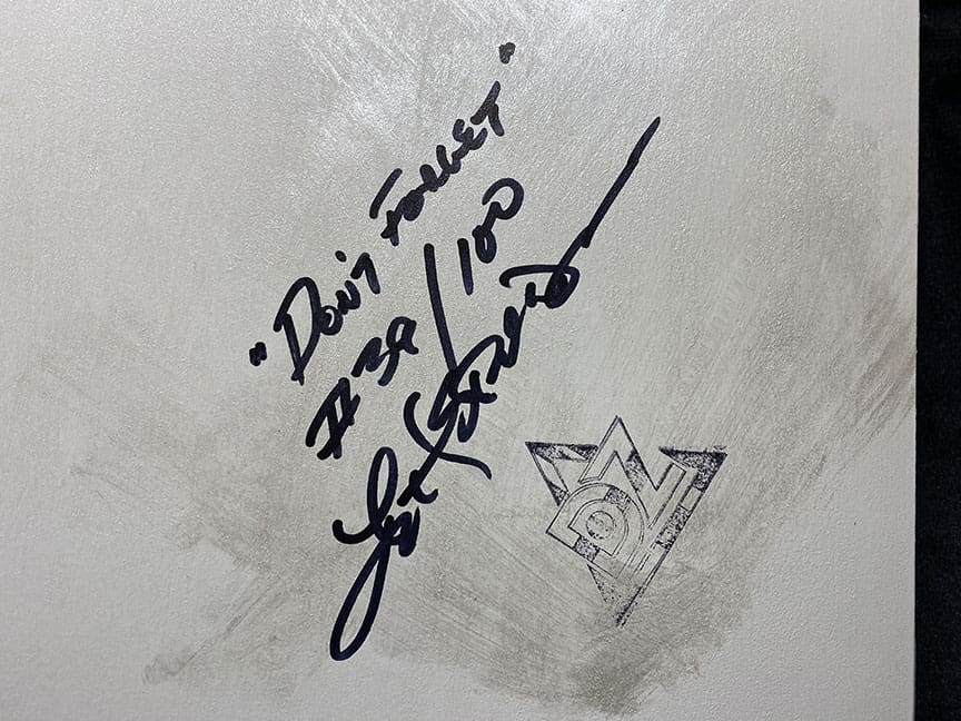 Autographed message with triangular logo sketch.