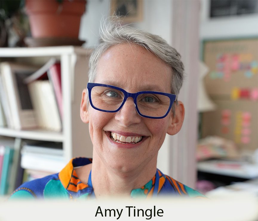 Smiling woman with short gray hair and glasses.